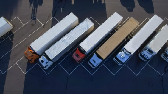 a line of heavy-duty semi trucks in parking lot
